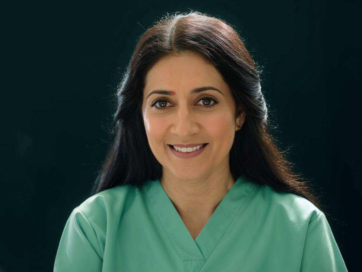 A dentist partner in sage-green scrubs